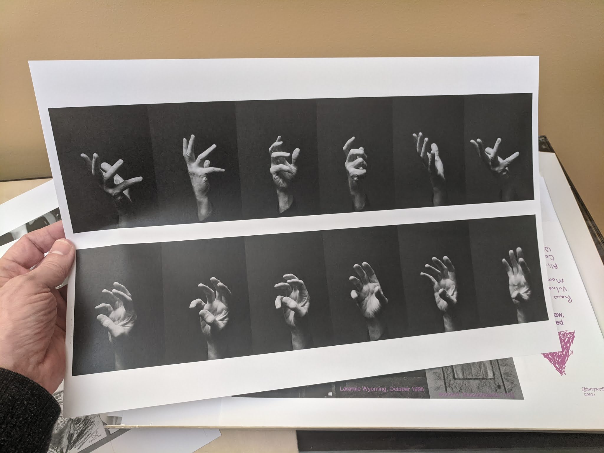 A print with multiple images of a hand against a black background. The hand appears to be changing position across successive images.